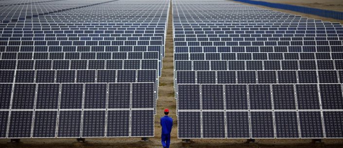 A worker inspects solar panels at a solar Dunhuang